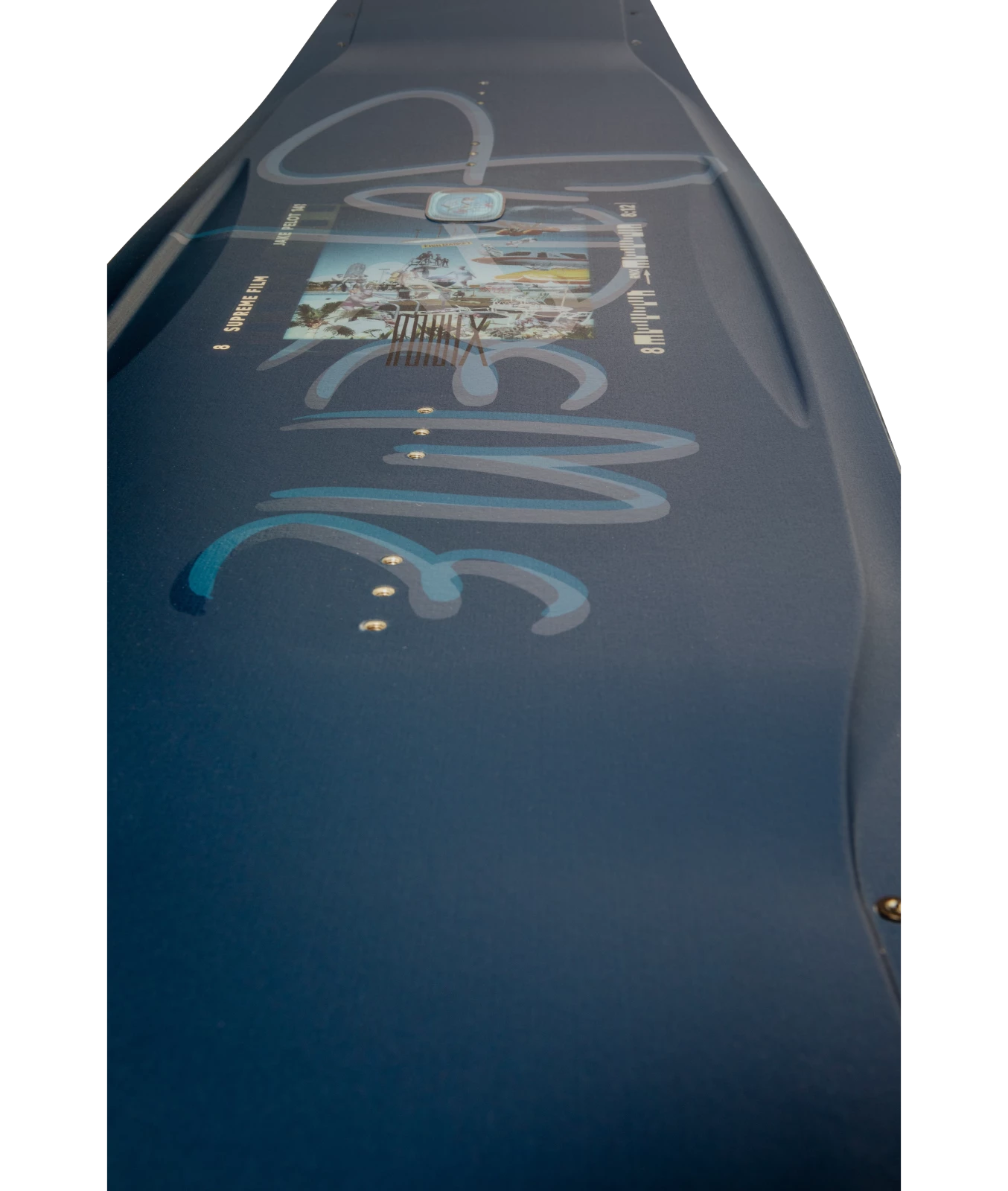 Ronix Supreme wakeboard graphic, angled top shot showing the Supreme logo and the lenticular badge. Dark blue background color, with clear ink over Supreme