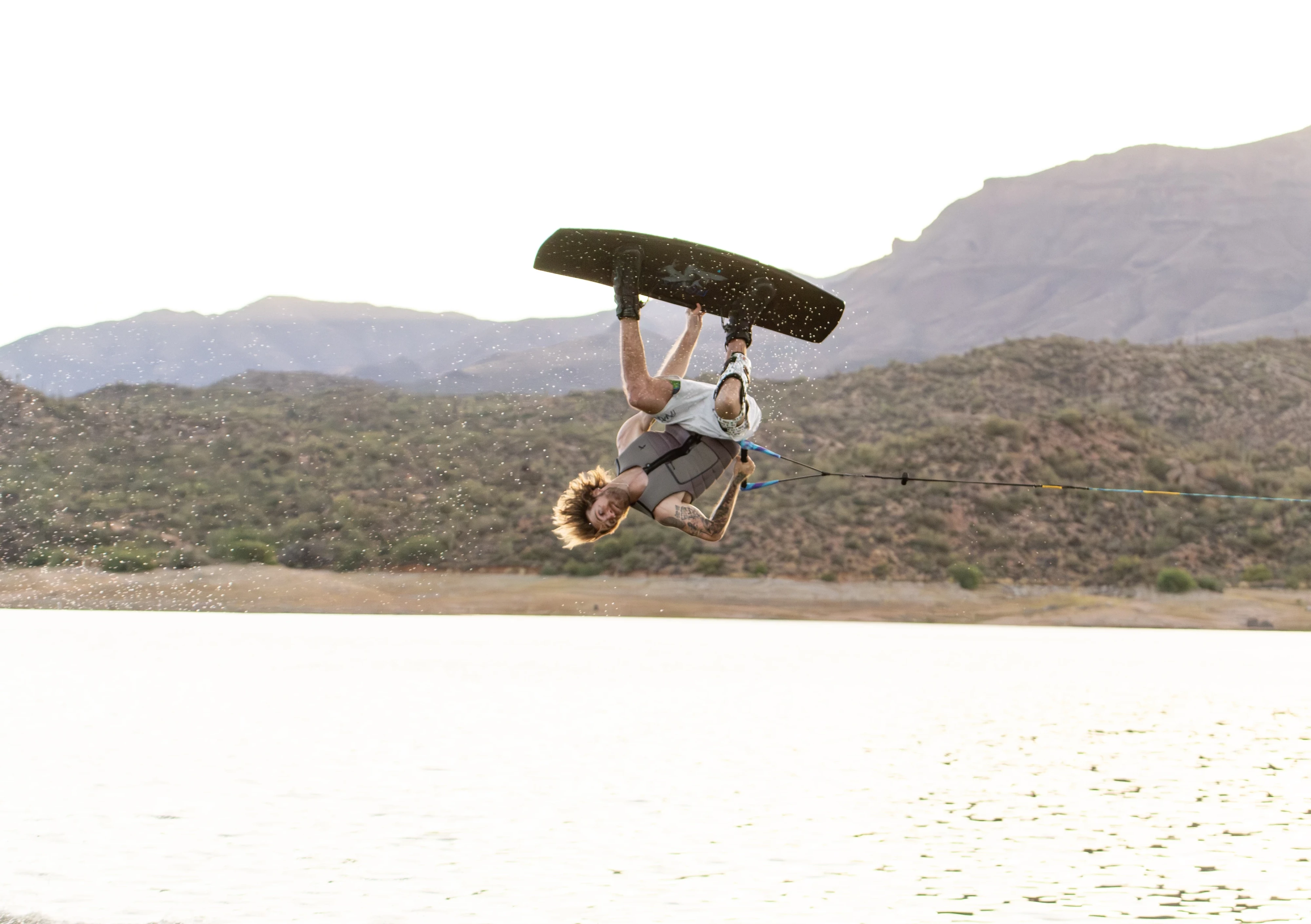 Action shot of Massi Piffaretti riding the Ronix RXT - Ronix Xperiemental Technology, with water and mountains in the background