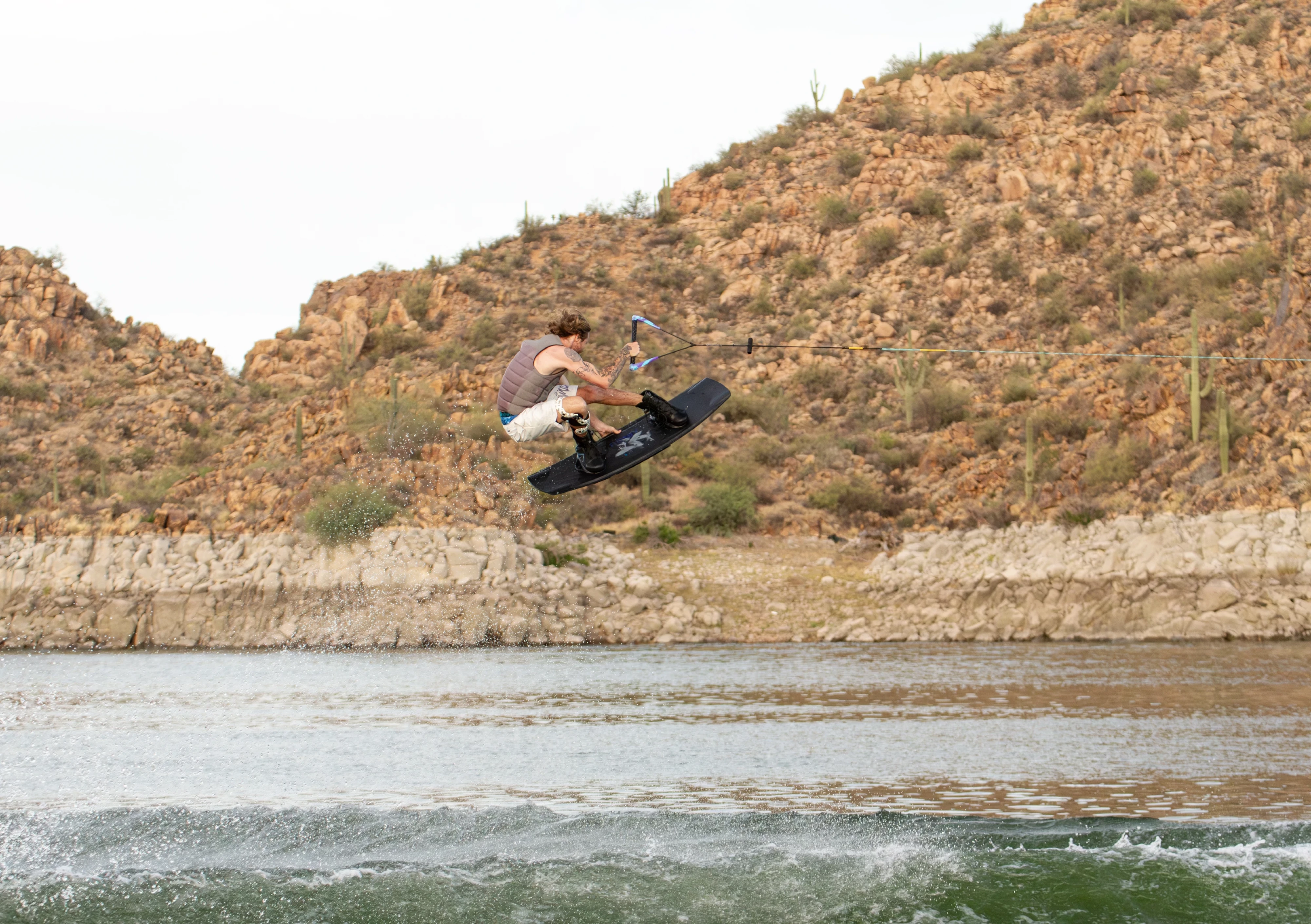 Action shot of Massi Piffaretti riding the Ronix RXT - Ronix Xperiemental Technology, with water and rocks in the background