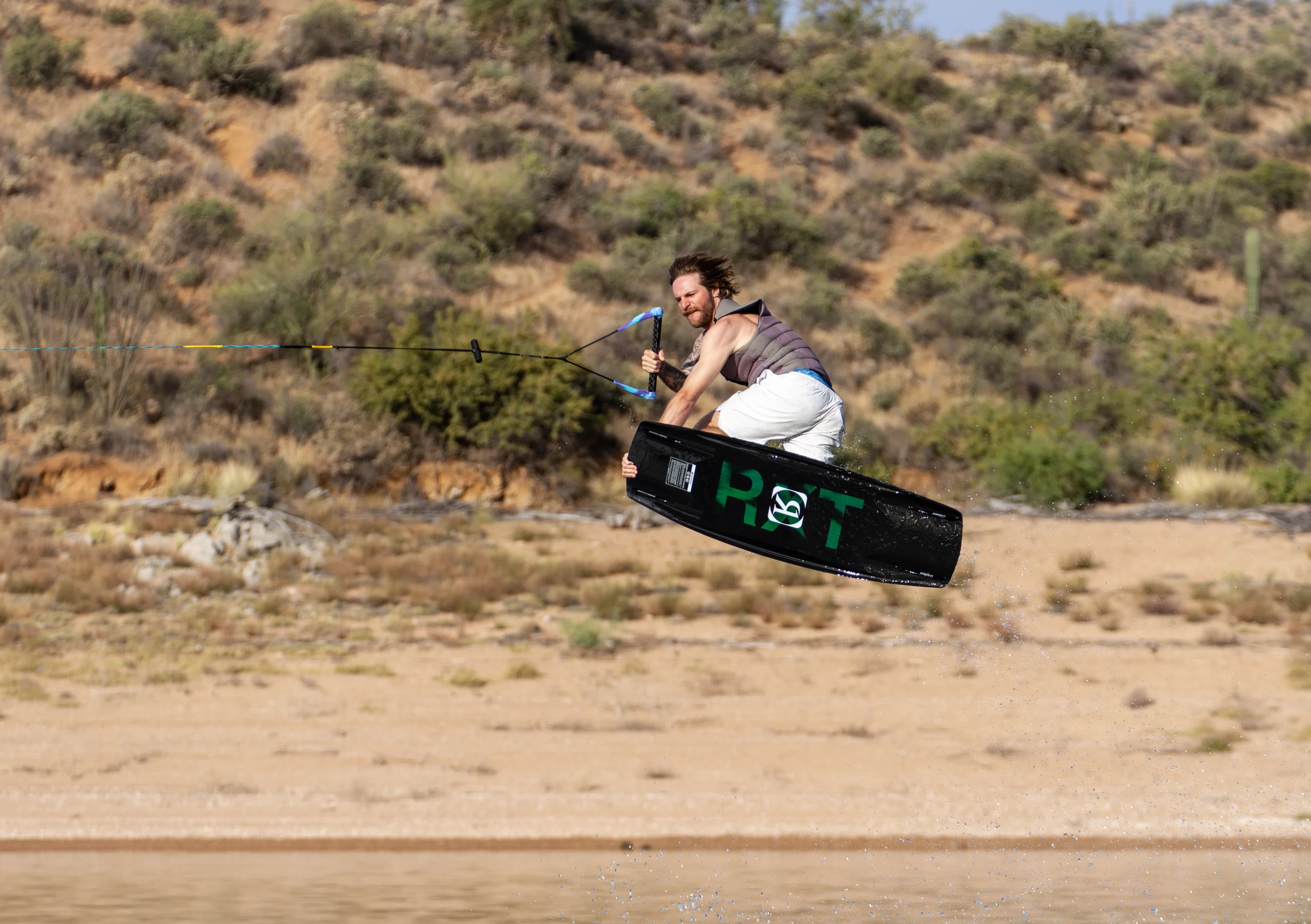 Action shot of Massi Piffaretti riding the Ronix RXT - Ronix Xperiemental Technology, with water in the background